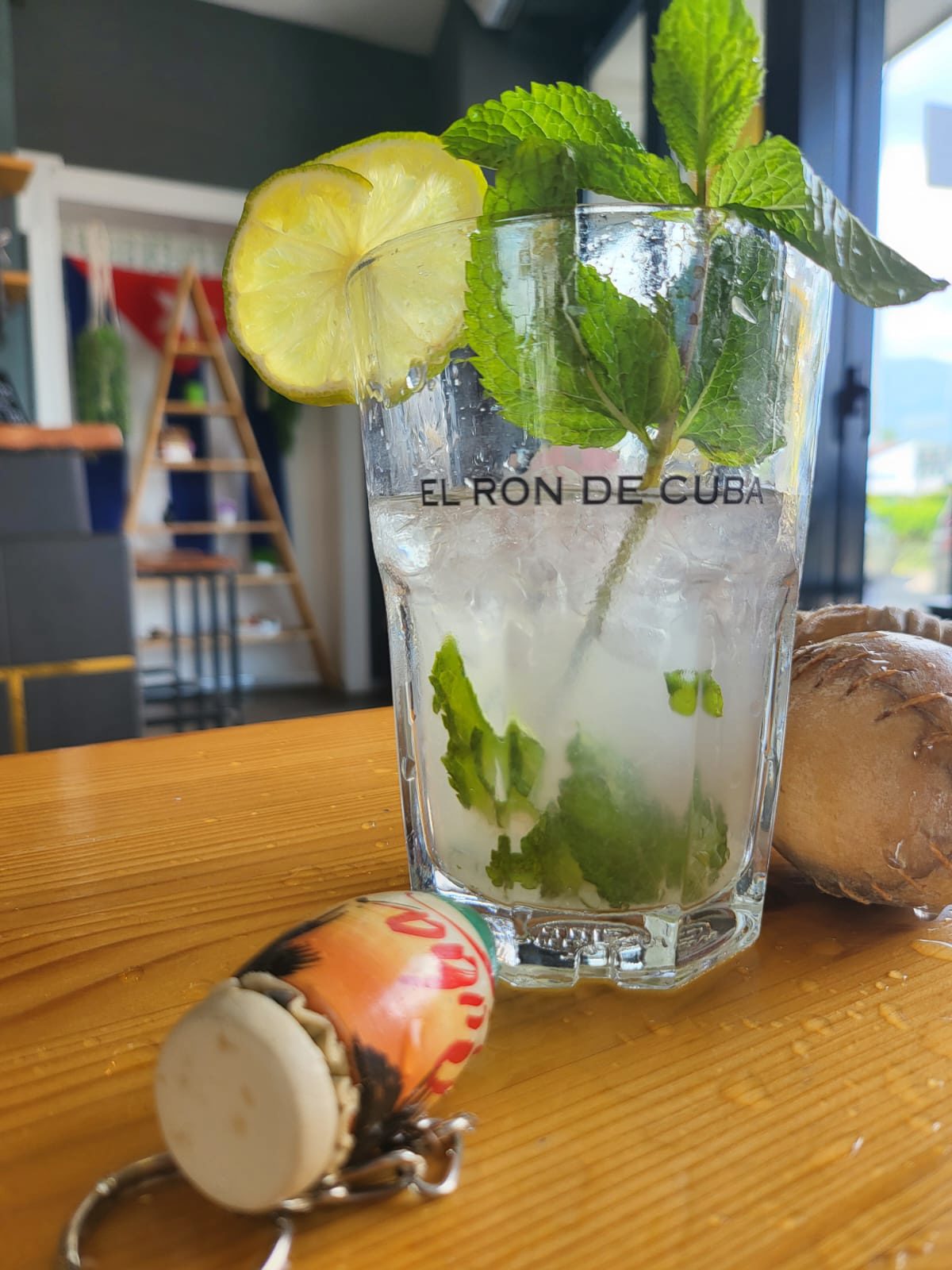 Mojito preparato al banco, con la bandiera cubana sullo sfondo